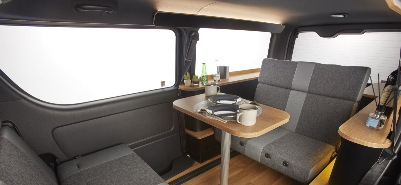 C-styleの車内。木目のテーブルを挟んで向かい合うシートと、窓から入る光
