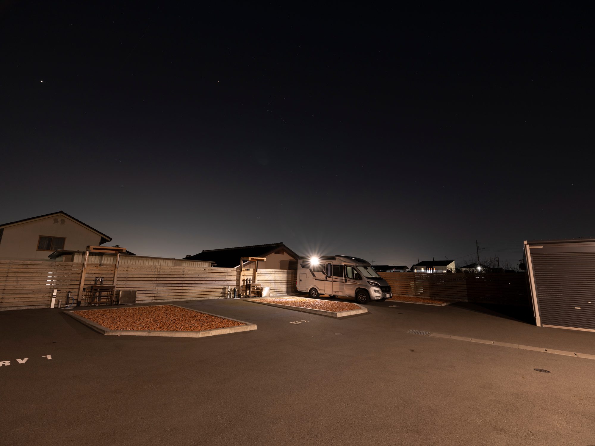 夜の区画全景。左に瓦チップのフリースペース、右にシャッターの倉庫