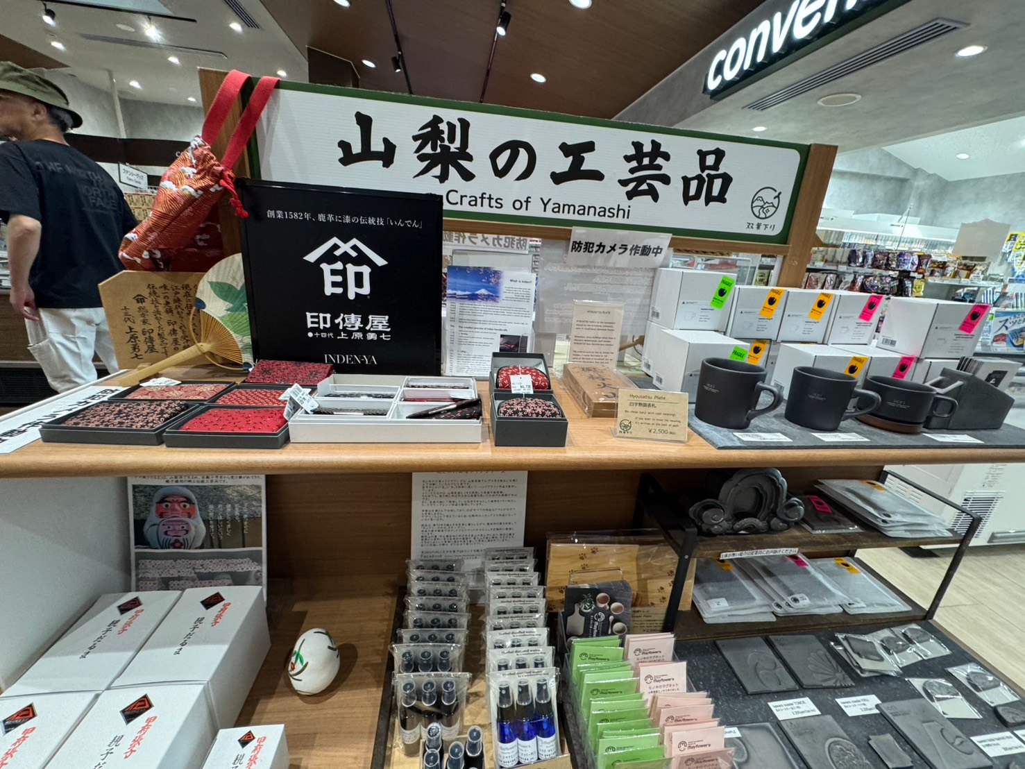 印傳屋の小物や黒いマグカップなどが並ぶ山梨の工芸品コーナー