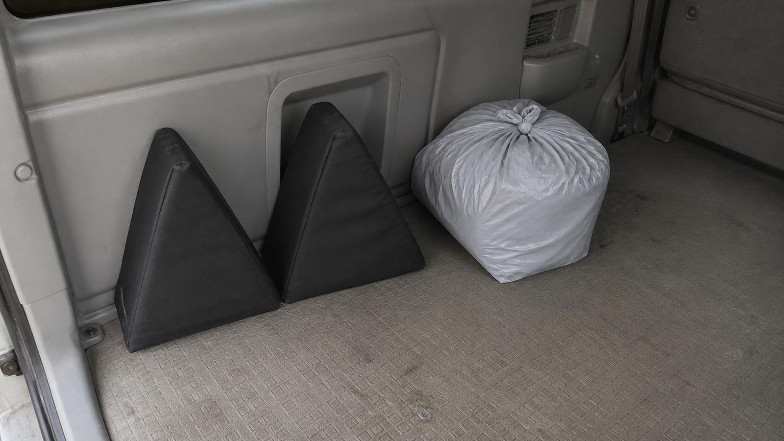 車内の隅に立てて収納された段差解消クッションと、袋に入れたレベラー