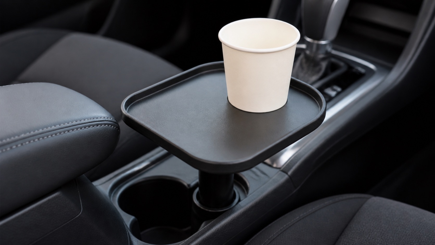 車のセンターコンソールの純正カップホルダーに差し込んだ小型トレイの寄り。トレイの上に紙コップが1つ載っている