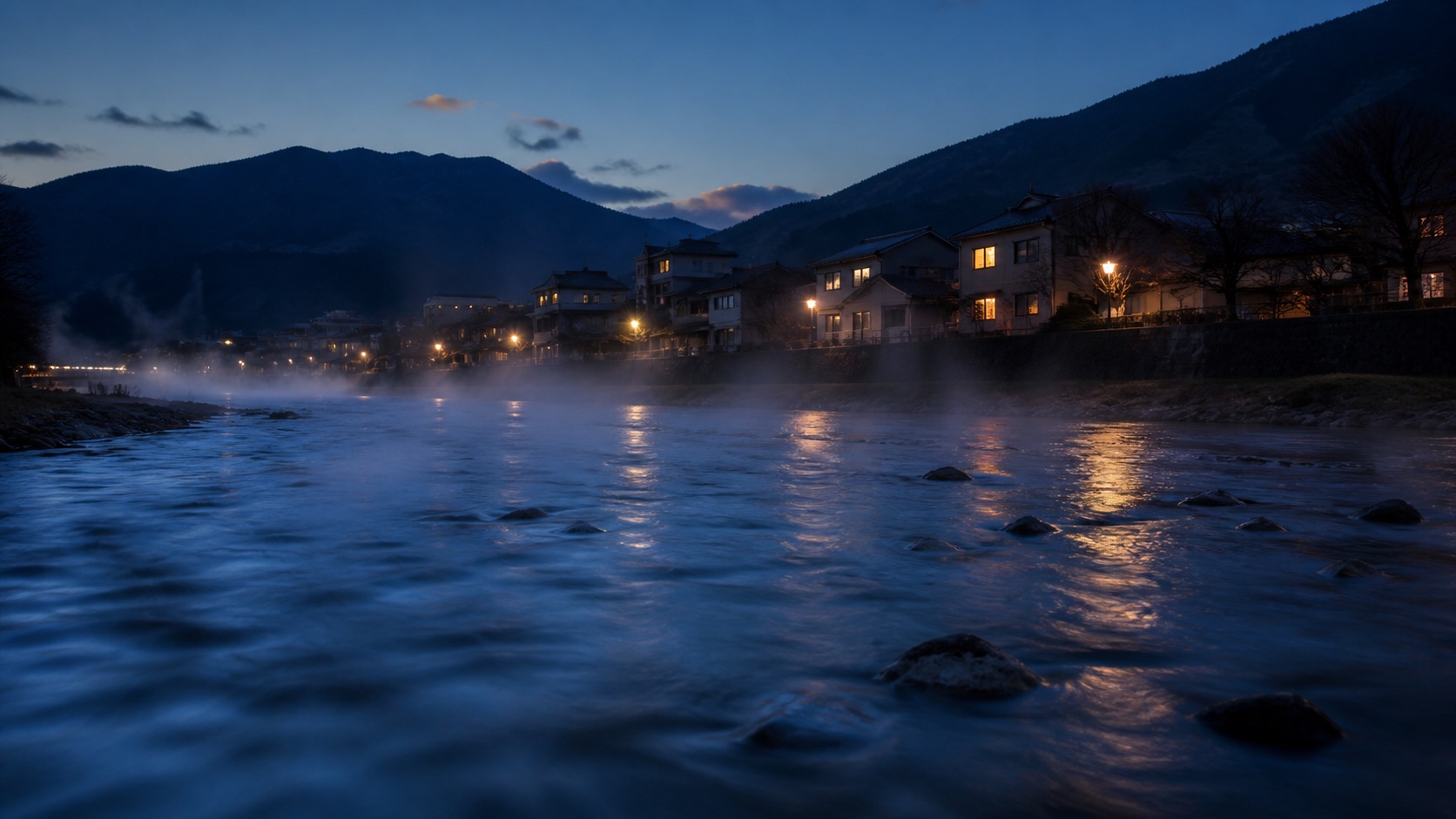 夕暮れの川沿いに立ち上る温泉地の湯気(イメージ)