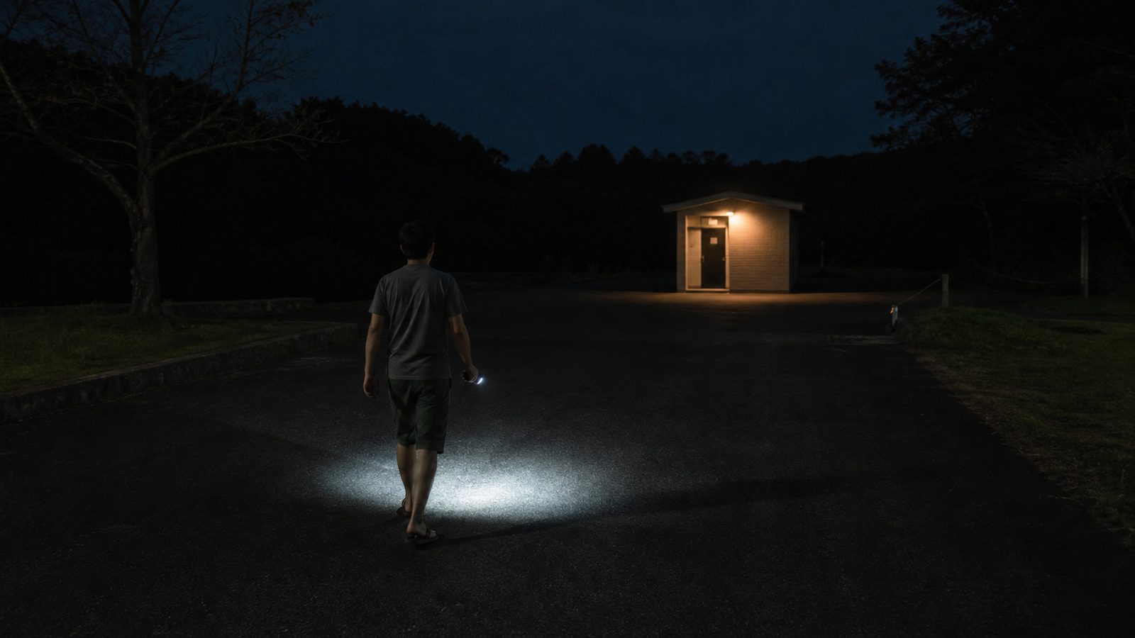 夜のRVパークで、区画から離れた屋外トイレへ歩く