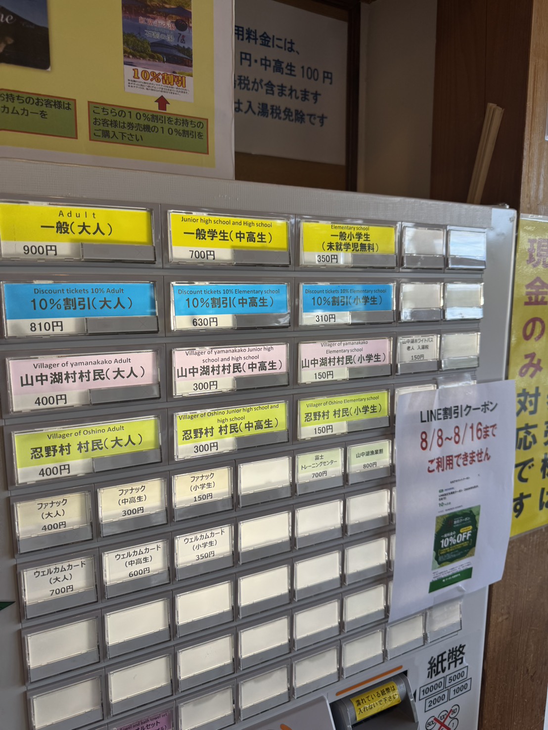 石割の湯の券売機の料金ボタン一覧。一般900円のほか、10%割引、山中湖村村民、忍野村村民、ウェルカムカードなどのボタンが並ぶ