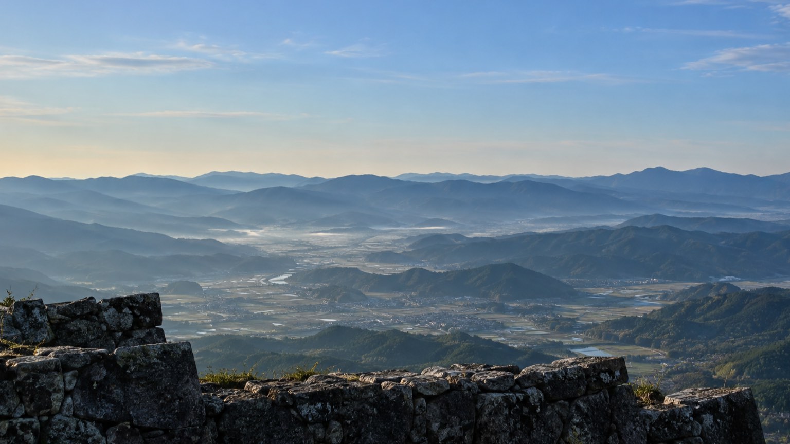 早朝の山頂から見下ろす盆地と山並み(イメージ)