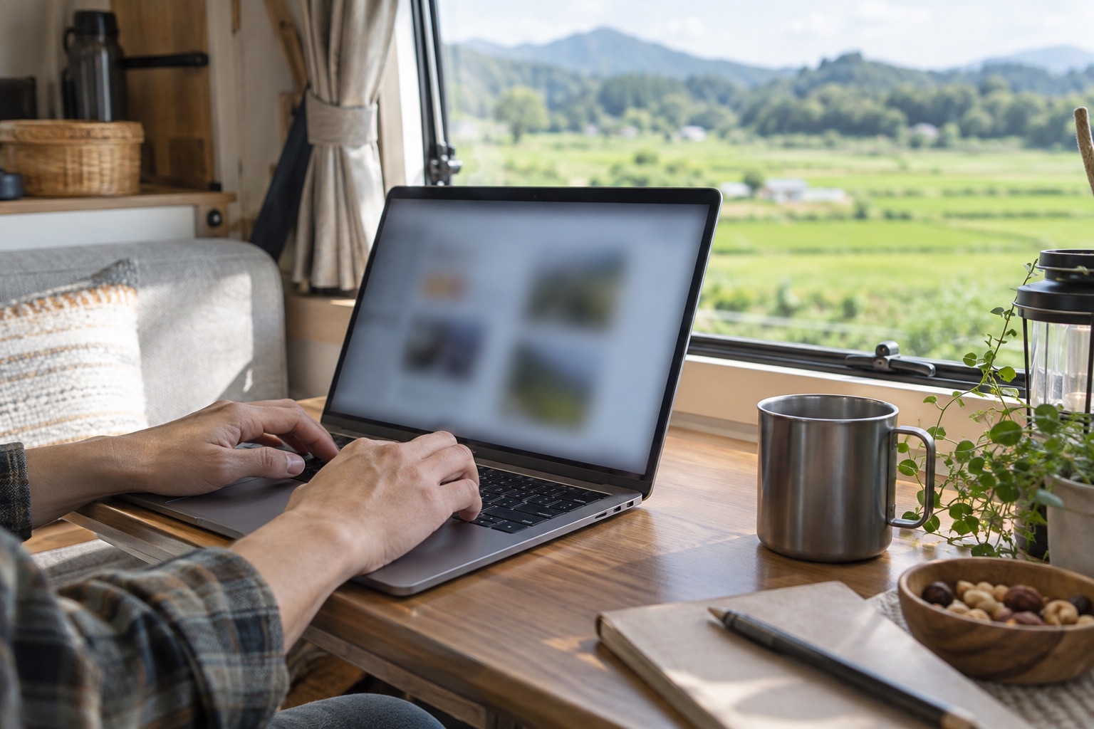 車内のテーブルでノートPCを開いて作業する手元(イメージ)