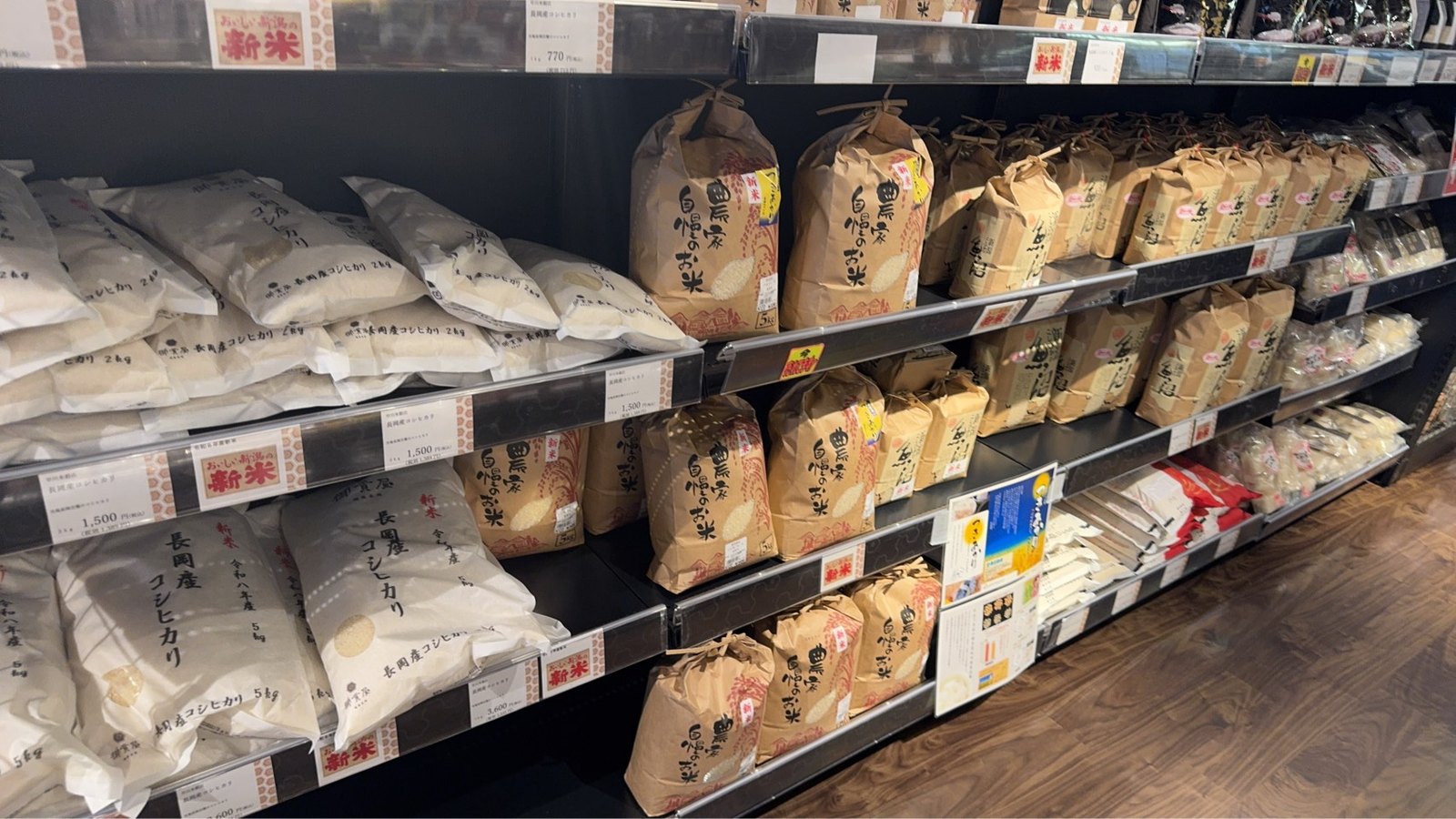 「おいしい新潟の新米」の札と長岡産コシヒカリ、魚沼産の米袋が並ぶ棚
