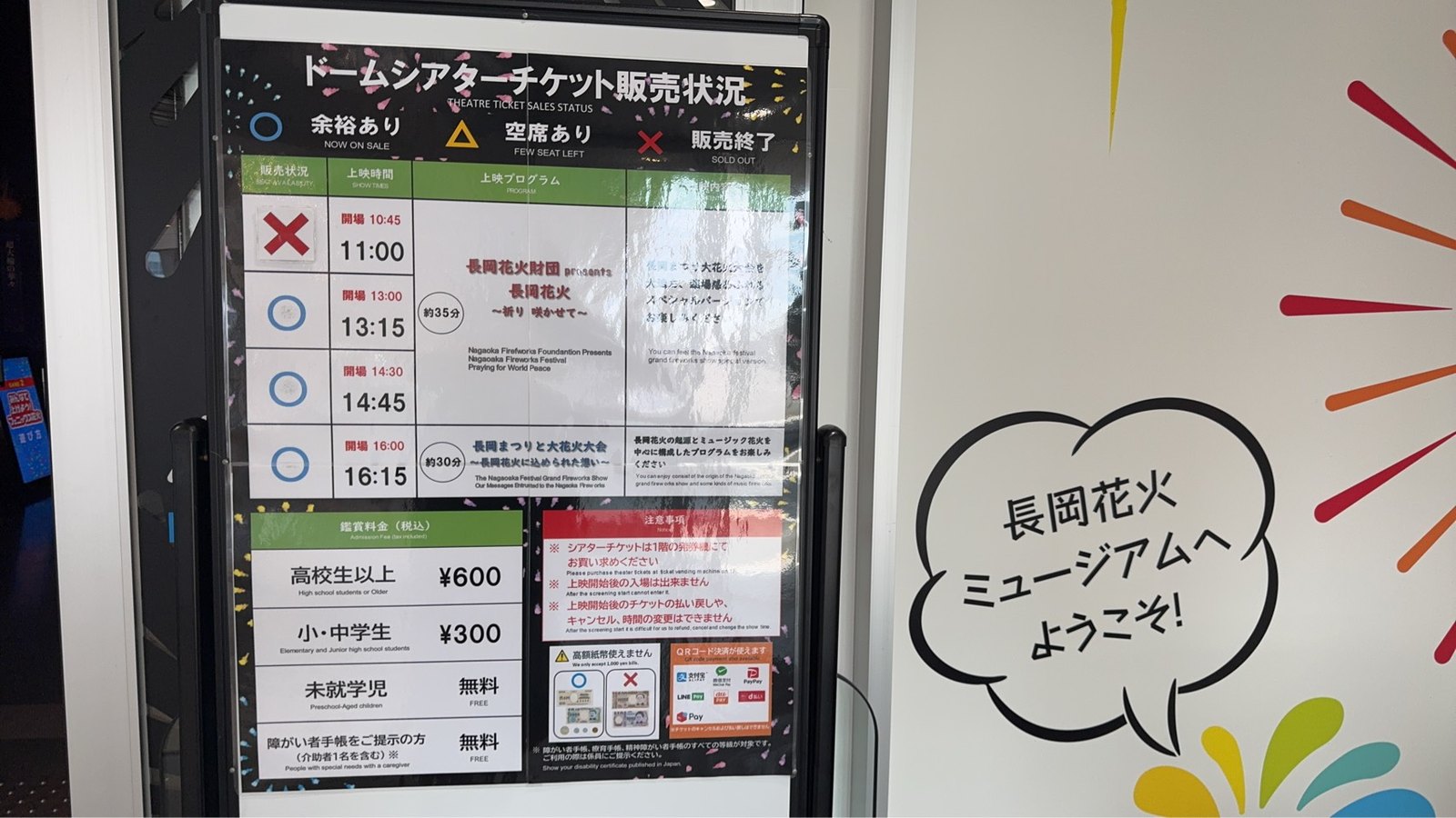 「ドームシアターチケット販売状況」の案内板。上映時間と鑑賞料金の掲示
