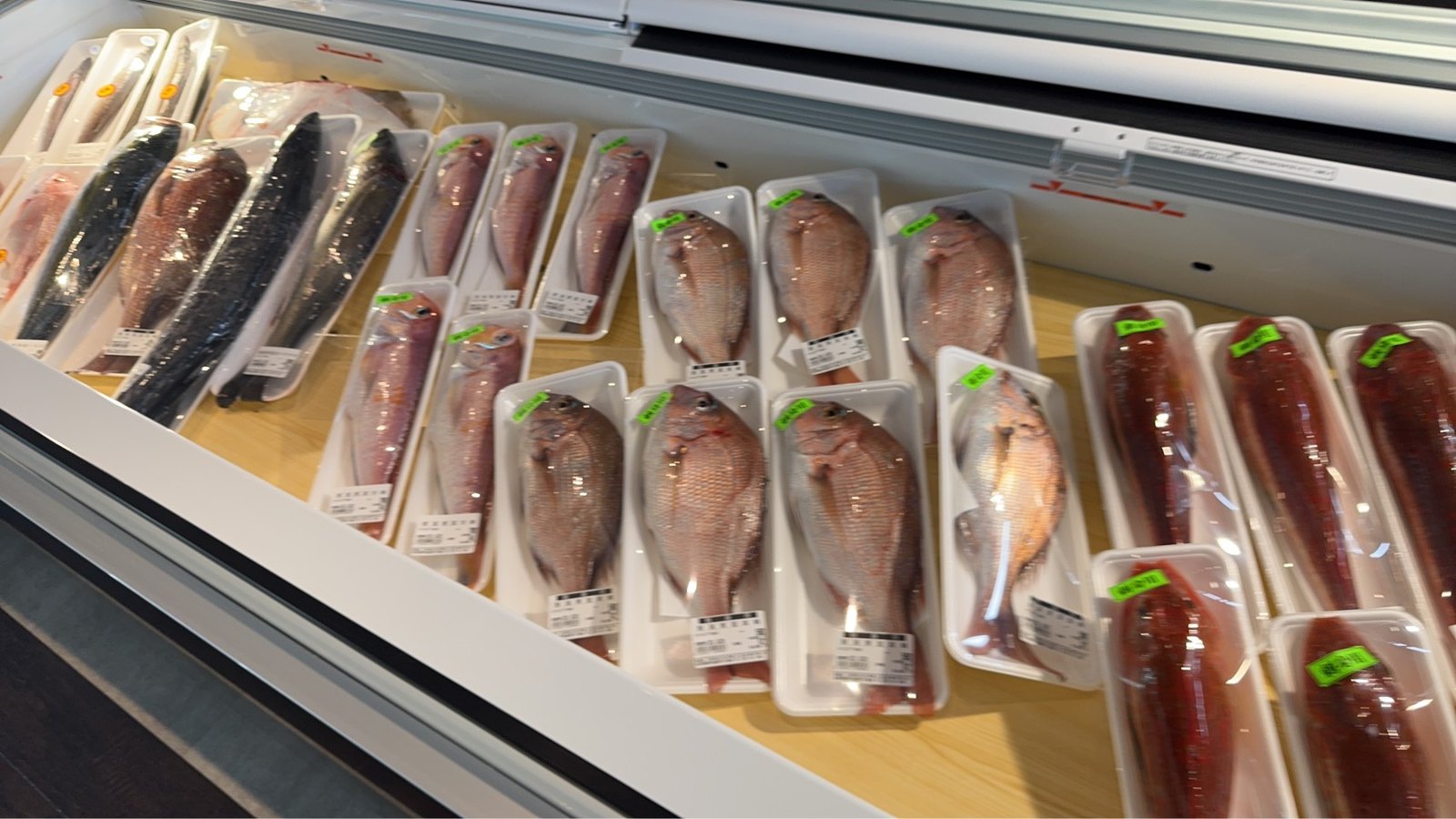 冷蔵ケースに並ぶ鯛などの鮮魚のパック