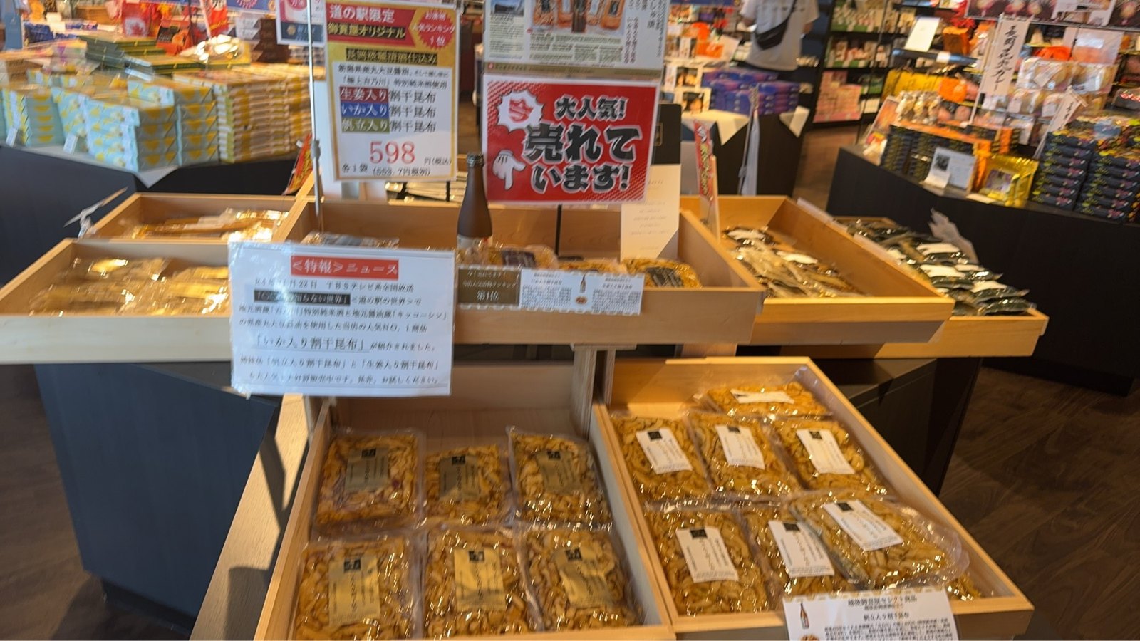木箱に並ぶ生姜入り・いか入り・帆立入りの珍味と598円の値札