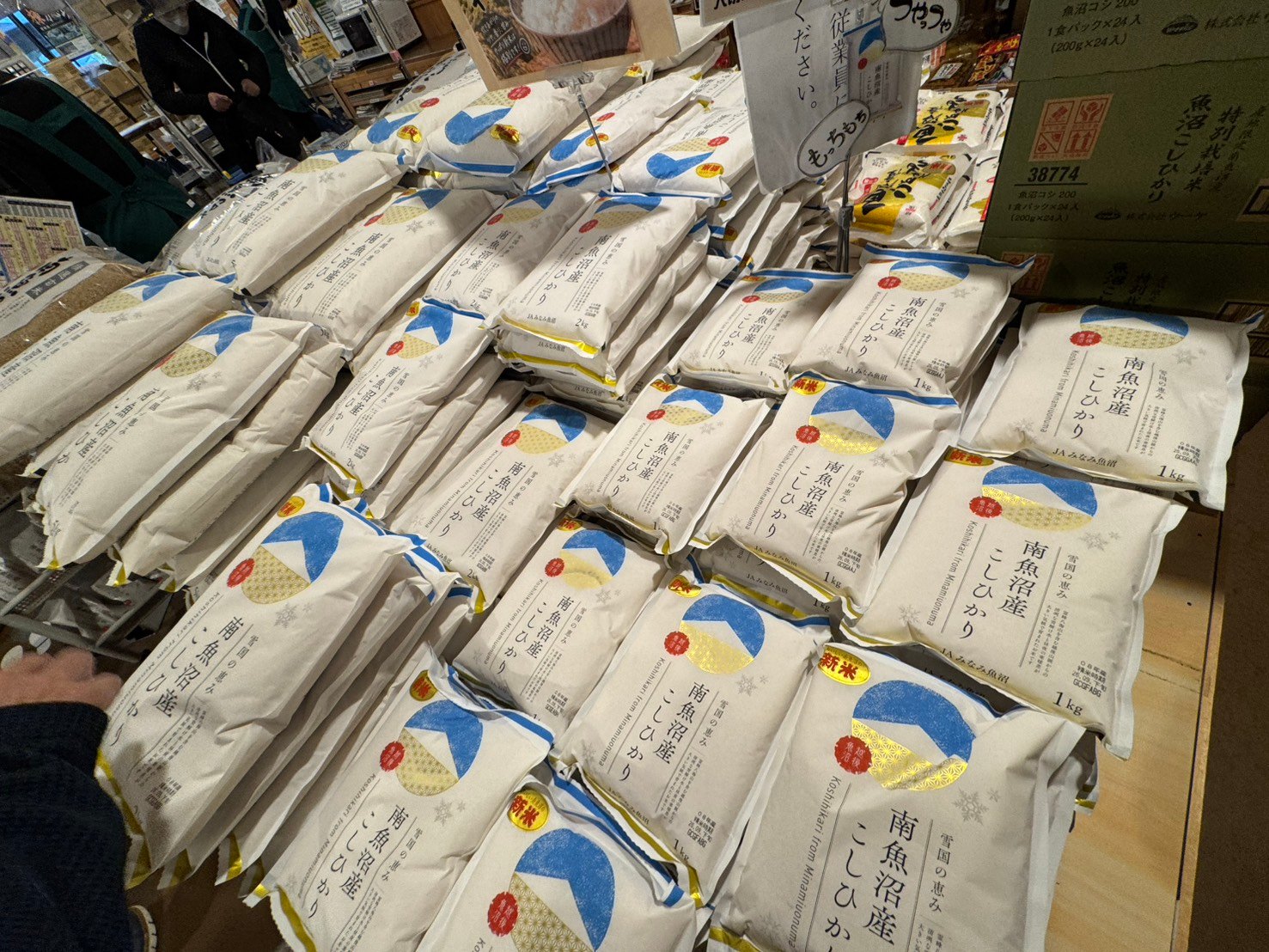 JAみなみ魚沼「南魚沼産こしひかり」の袋が山積みの売場。新米シールと「もっちもち」「つやつや」のPOP