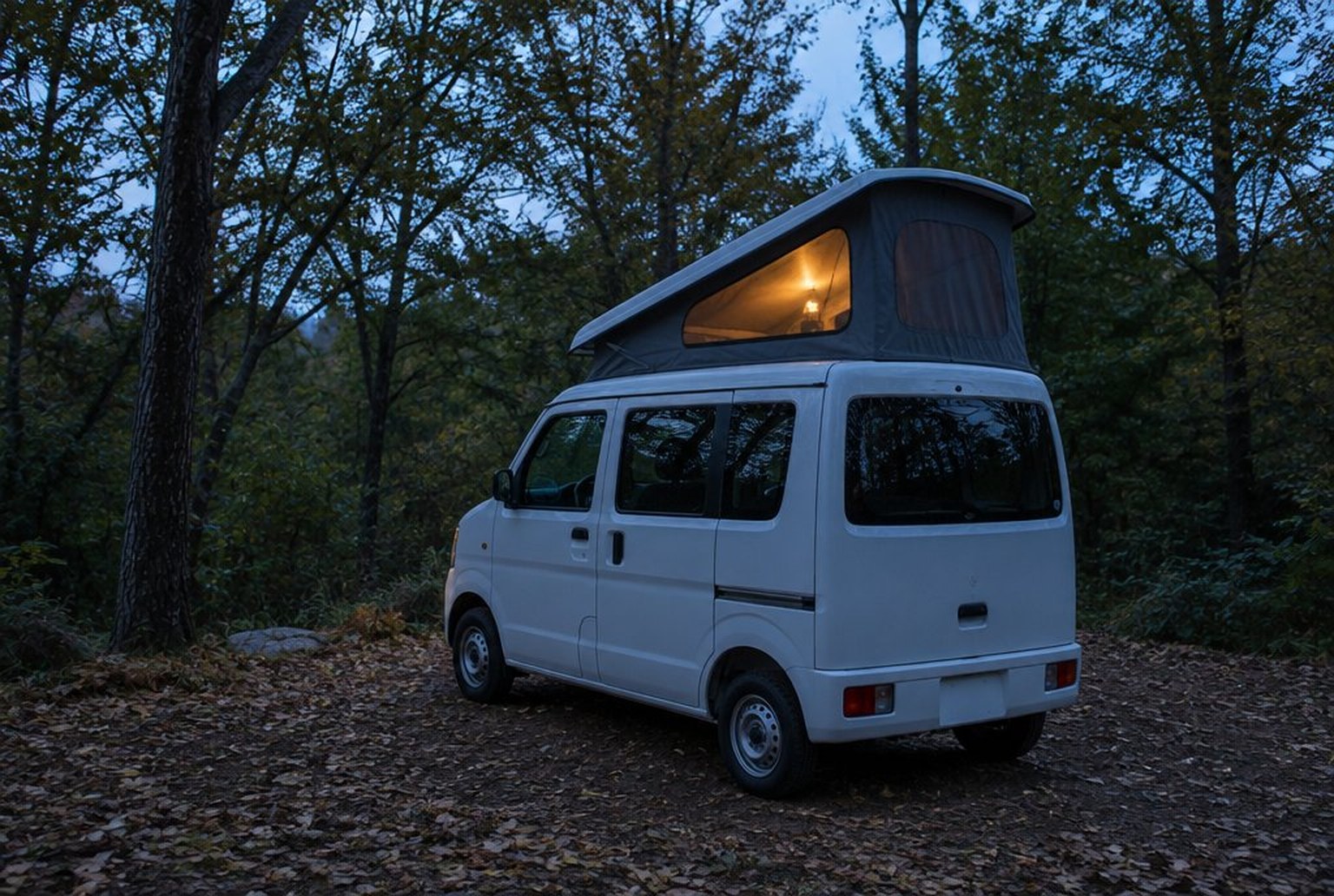 夕暮れの林間のキャンプ場で、白い軽バンの屋根がテントのように持ち上がり、中のランプの明かりが布越しに透けている（イメージ画像（AI生成。実際の施設・商品の写真ではありません））