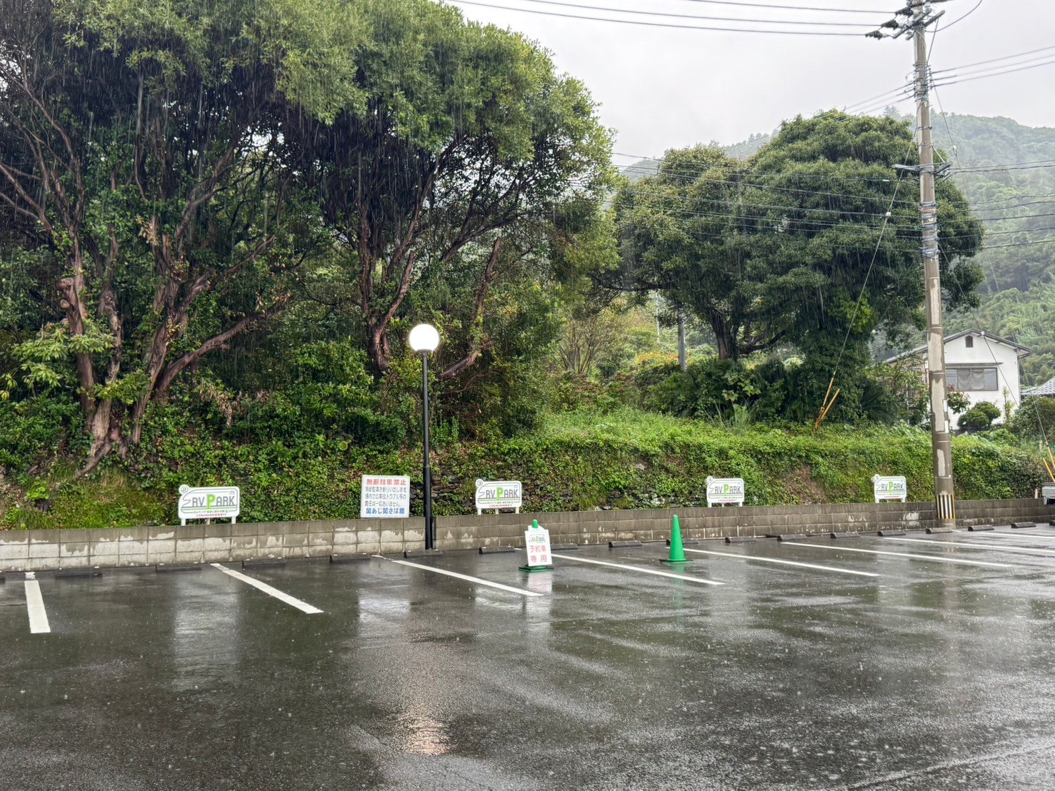 白線で区切られた舗装の駐車区画と、RVパークの看板、予約専用の表示