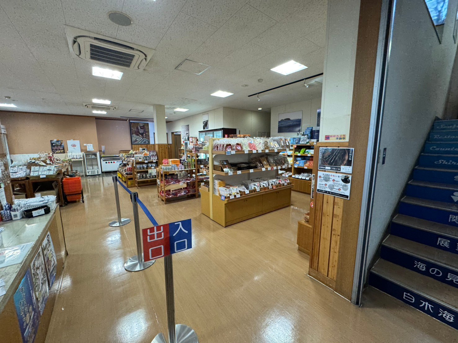 入口と出口の表示がある売店と、袋入り・箱入りの商品が並ぶ棚